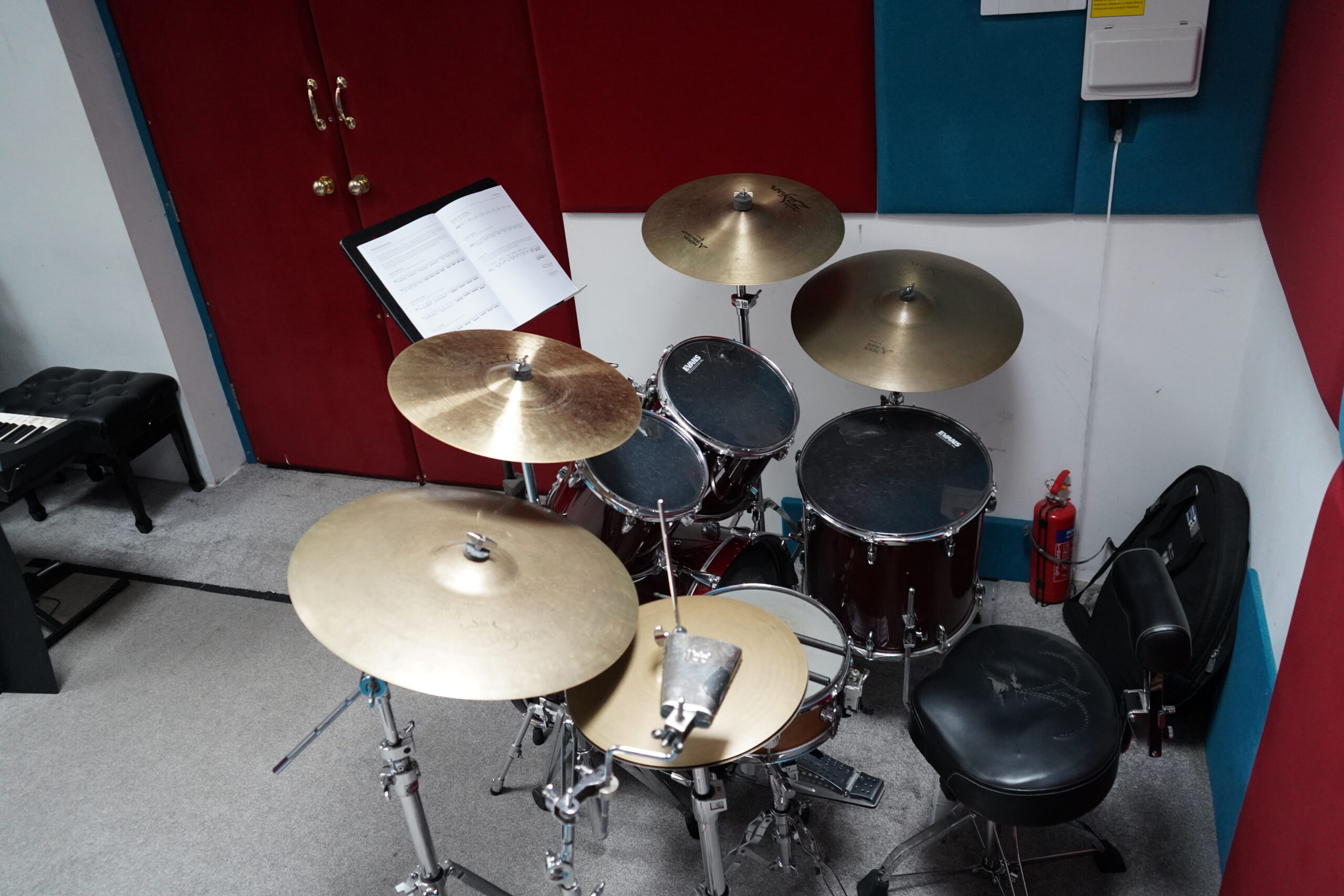 Overhead view of the acoustic drum kit at Harrow Music Studio with cymbals, throne and sheet music