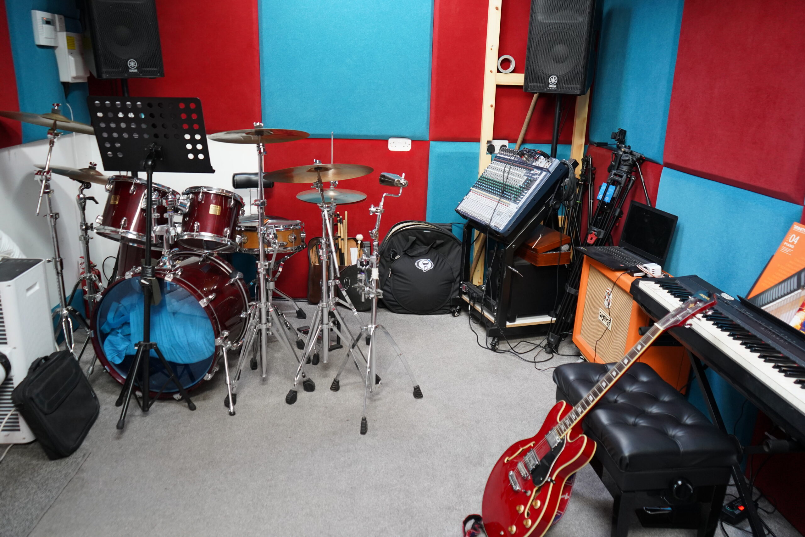 Wide view of the studio from one end, showing drum kit and mixing desk